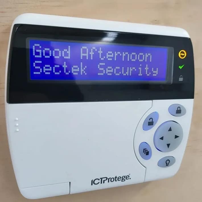 Sectek Security alarm system keypad displaying Good Afternoon message on blue LCD screen